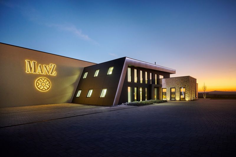 Die LED-Leuchtschrift „Manz“ setzt die moderne Fassade des Weinguts in Szene. Die gefertigten 3D-Leuchtbuchstaben mit energieeffizienter LED-Technik sorgen für eine gleichmäßige Ausleuchtung und machen das Firmenlogo bereits aus großer Entfernung sichtbar. Diese professionelle Lichtwerbung für Fassaden verbindet moderne Architektur mit hochwertiger Werbetechnik und stärkt die Markenpräsenz des Weinguts