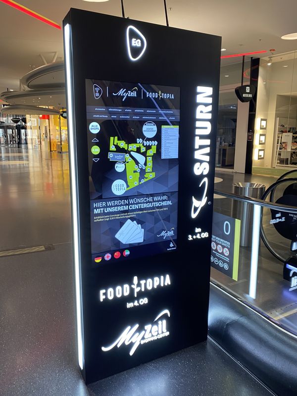 Digital Signage Stele im MyZeil Shopping-Center vereint modernste Informationstechnologie mit hochwertigem Design. Die Stele verfügt über einen interaktiven Touchscreen zur Orientierung (