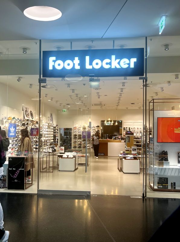 Ein installierte Ausstecktransparent (Nasenschild) für den Foot Locker Store im MyZeil Frankfurt. Als zentrales Element der Eingangsportal-Beschilderung ragt der hochwertige Leuchtkasten in den Laufweg hinein. Die flache Bauweise mit homogener LED-Ausleuchtung des ikonischen Logos sorgt für ein modernes sichbares Erscheinungsbild des Ladenbereichs innerhalb der Mall.