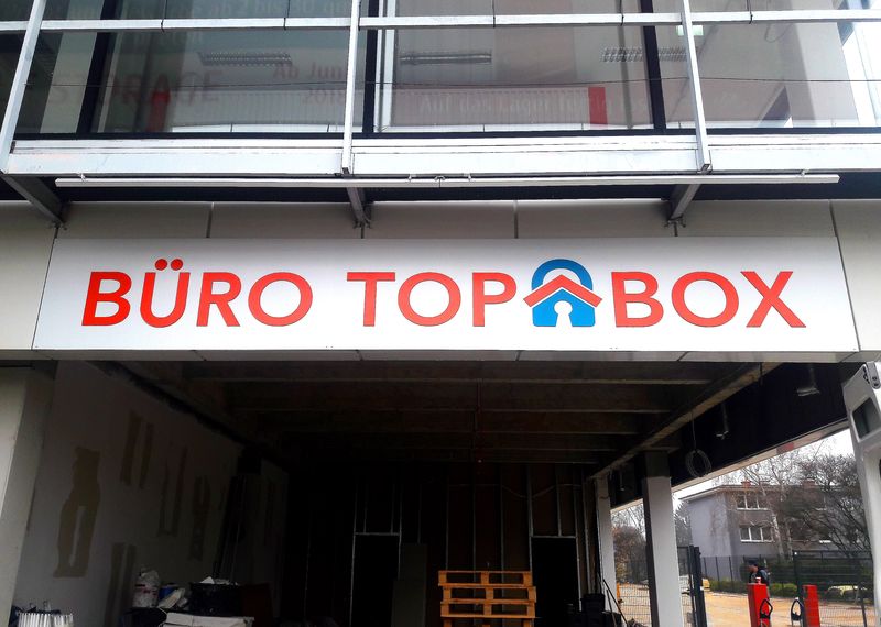 Unsere fachgerecht montierte Fassadenwerbung für TOP BOX sorgt für unübersehbare Präsenz am Standort. Die rot-weiße Gestaltung dem Dibond-Schild sorgt für einen hohen Kontrast und sofortige Wiedererkennung.