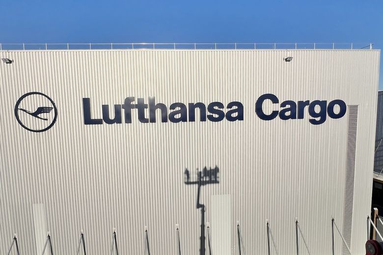 Die Webeanlage am Gebäude ist eine umlackierte und neu montierte „Lufthansa Cargo“-Schriftzug inklusive Kranich-Logo. Die XXL-Fassadenwerbung ist ein umfassendes Refurbishment  bei einer über 12 Meter hohen Fassaden-Werbeanlage.