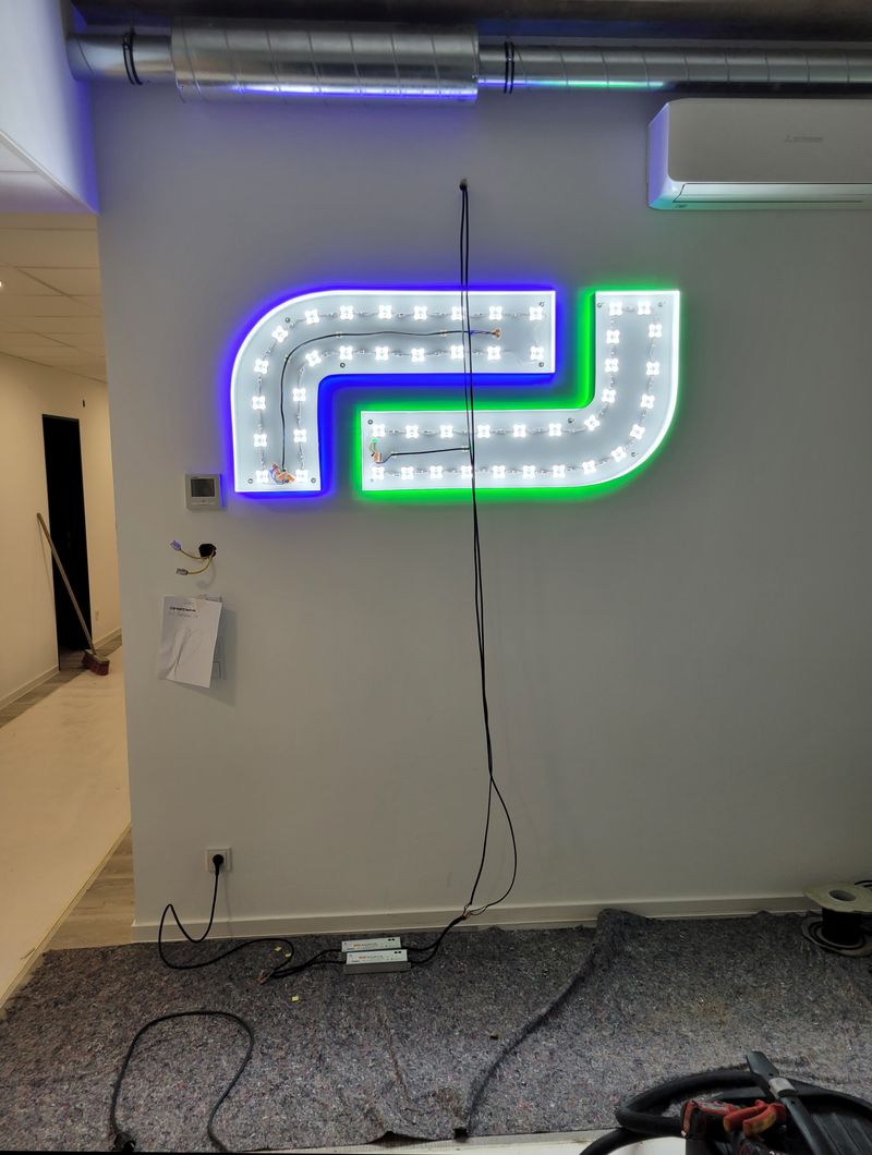 Während der Montage werden die einzelnen Profil-Firmenlogo-Elemente exakt nach Montageplan ausgerichtet und angeschlossen. Die integrierte LED-Technik sorgt später für eine gleichmäßige Rückbeleuchtung und Frontbeleuchtung. Nematec Display Factory übernimmt die komplette Fertigung, Verkabelung und Montage individueller LED-Leuchtschriften für Unternehmen.