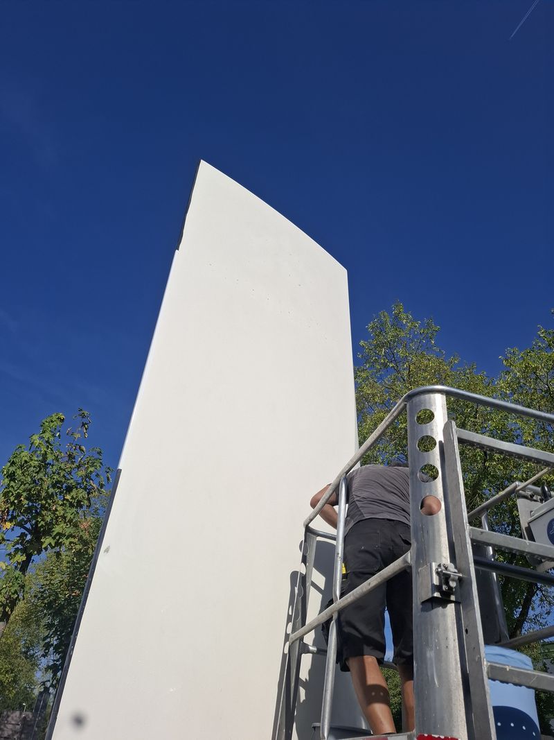 6m Pylon Authaus Hoeptner Montage für den Pylon erfolgte mit Hubarbeitsbühne, sodass die großformatigen Folien passgenau auf den gebogenen Pylonflächen verarbeitet werden konnten. Gerade bei dieser Höhe und den gewölbten Flächen kommt es auf millimetergenaue Ausrichtung und eine blasenfreie Verklebung an.