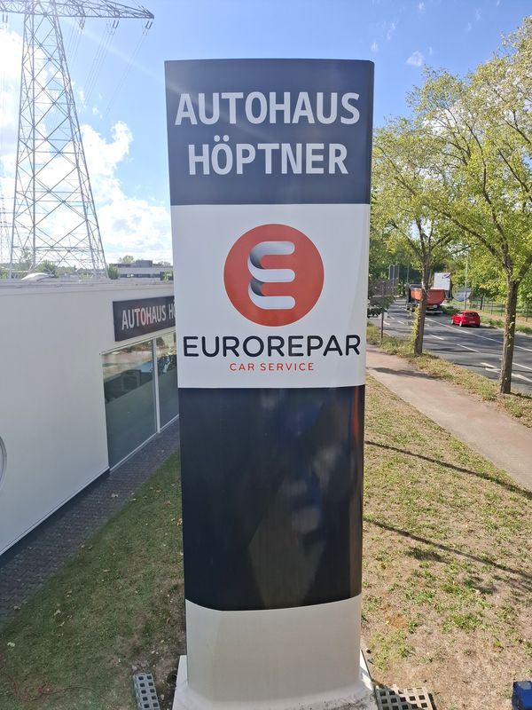 Fertig beschrifteter 6 Meter Werbepylon des Autohauses Höptner mit EUROREPAR-Logo und Verkaufsbeschriftung.